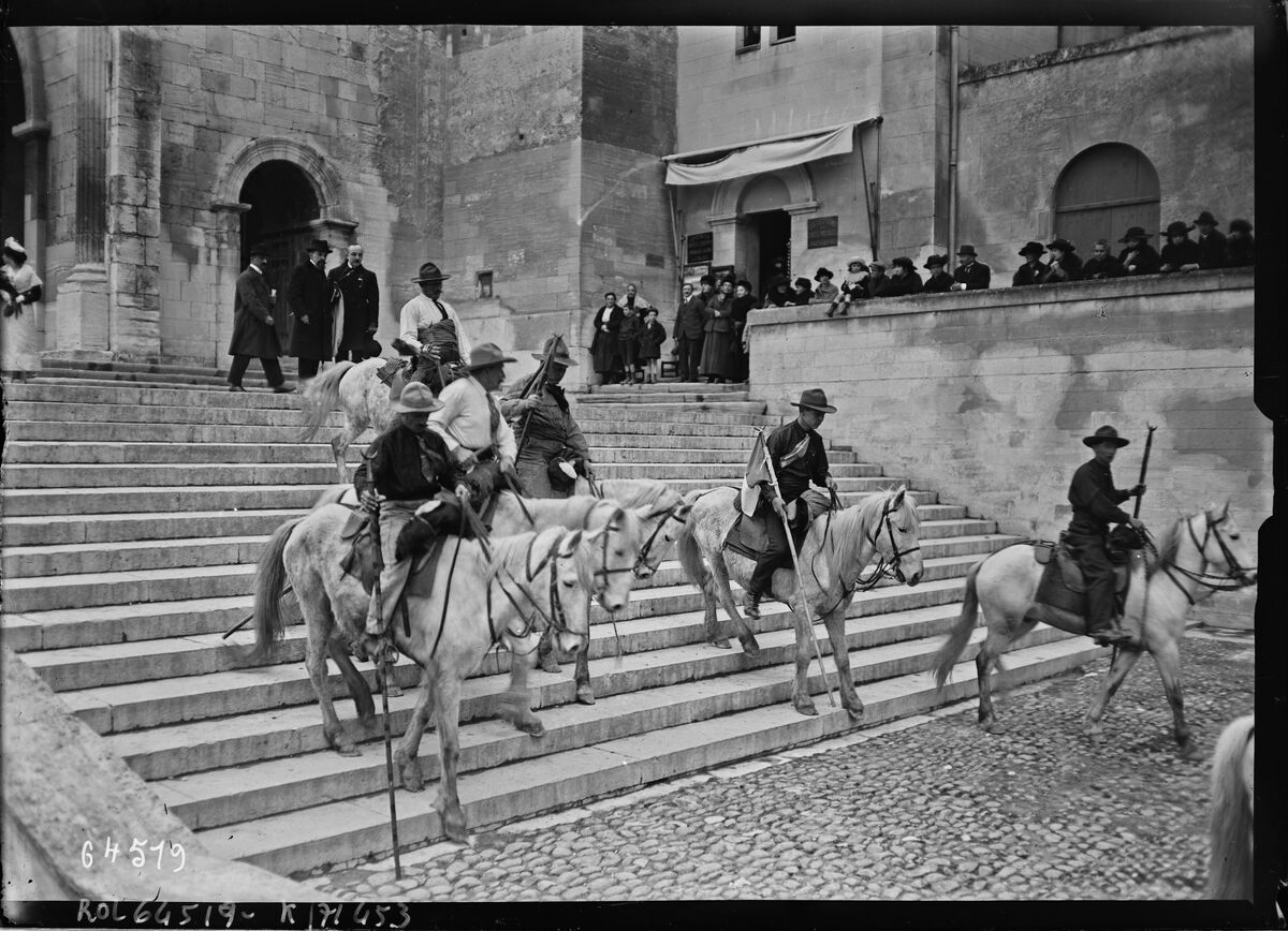 Visite au château [i. e. Palais] des Papes à Avignon [de M. Millerand, gardians camarguais descendant l'escalier du palais, le 15 mars 1921] : [photographie de presse] / [Agence Rol]