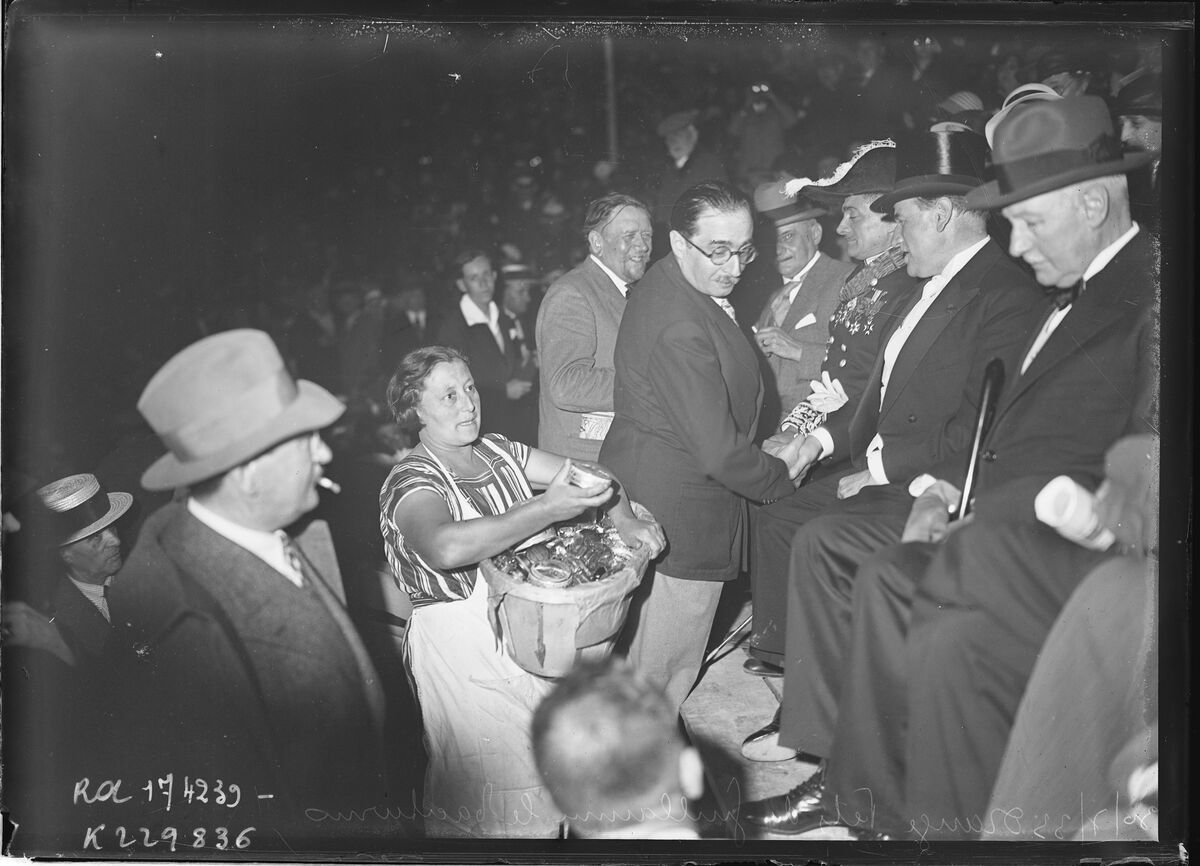 30/7/33, Orange, fêtes de Guillaume le Taciturne [au théâtre antique, une vendeuse propose une boîte de friandises à M. Daladier] : [photographie de presse] / [Agence Rol]